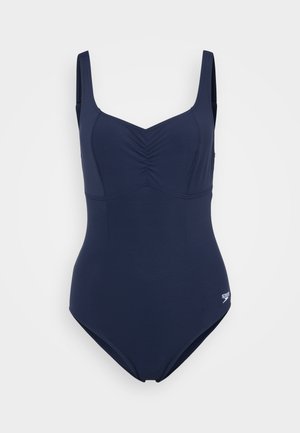 Marineblauwe badpak met verstelbare schouderbanden, geplooide voering en een gladde textuur. Wordt gekenmerkt door een klein logo aan de zijkant.