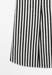 Black and white vertical striped fabric with a slight texture and a central overlapping slit at the bottom.