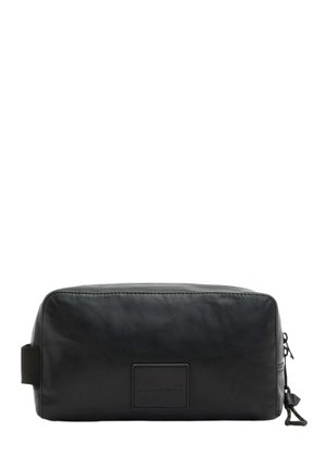 Neceser de piel negra con forma rectangular, textura suave, asa lateral y un pequeño bolsillo con cremallera. Presenta un parche de marca.