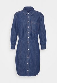 Džínová košilová šaty s dlouhými rukávy, zapínáním na knoflíky a jednou náprsní kapsou. Mají nařasený pas a mírně tapered lem.