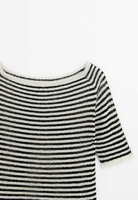 Haut en maille à manches courtes rayé horizontal noir et blanc avec un large col rond sur fond blanc.