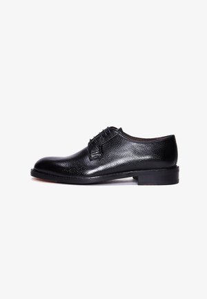 Zwarte leren dress shoe met een gestructureerde afwerking, ronde neus, vetersluiting aan de voorkant en een lage, stevige zwarte zool.