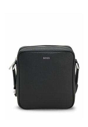 Sort firkantet crossbody taske med sølv BOSS-logo og dobbelte lynlås på justerbar skulderrem.