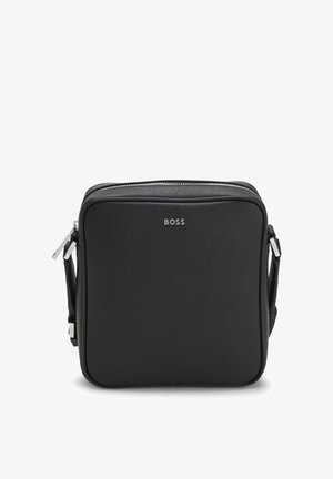 Schwarze quadratische Crossbody-Tasche mit silbernem BOSS-Logo und doppeltem Reißverschluss am verstellbaren Schulterriemen.