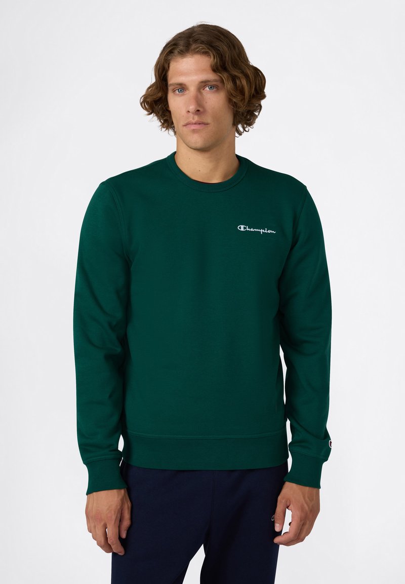 Sudadera de algodón verde con mangas largas, cuello redondo y logotipo bordado en el pecho. Puños y dobladillo acanalados. Diseño simple y ajustado.