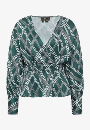 Zaļa satīna apakšblūze ar baltu ķēdes ornamentu, V veida kakla izgriezums, garas piedurknes un savilktā josta, ar gludu, maigu tekstūru.