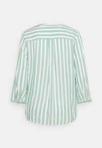 Blusa a rayas verdes y blancas con mangas tres cuartos, que presenta un yugo en la parte posterior y detalles de botones en los puños para el cierre.