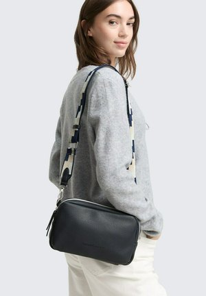Sac en cuir croisé bleu marine avec une finition texturée ; dispose d'une sangle en tissu à motifs beige et bleu marine ; fermeture éclair et sangle réglable.