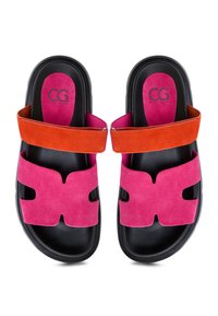Sandali in suede rosa con design ritagliato, dotati di una cinturino arancione. Suola nera con logo sulla soletta imbottita.
