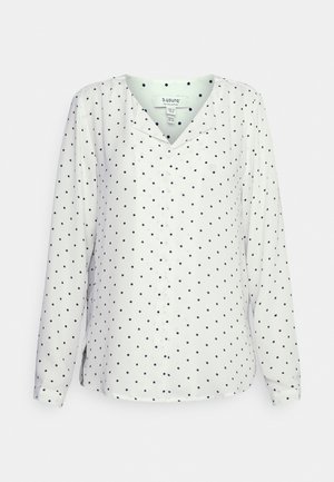 Balta garām piedurknēm krekls ar tumši zilu punktiņu rakstu, V-veida izgriezumu un pogu priekšpusi. Gluda auduma ar nelielu spīdumu un sānu slīpām atverēm ērtībai.