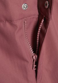 Rose-colored fabric with a herringbone pattern, featuring a pink zipper and snap fastener. Close-up shows texture and stitching details.