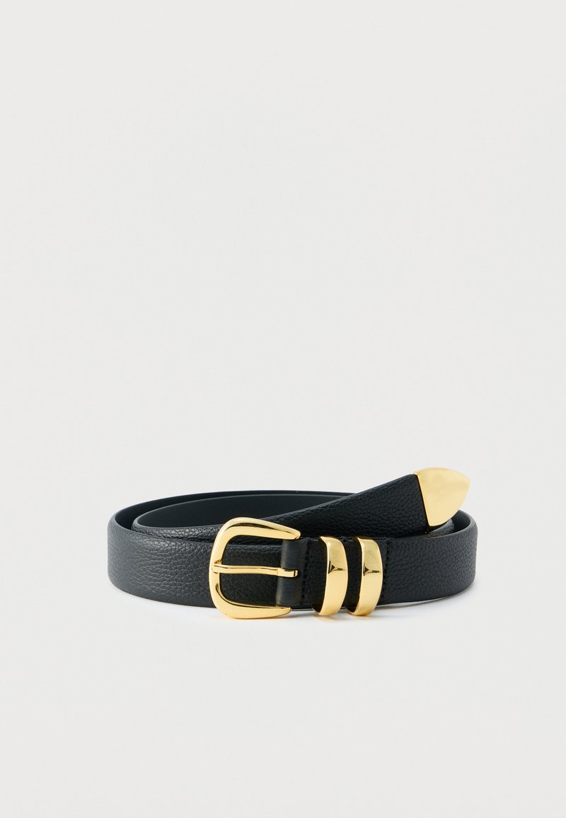 Ceinture en cuir texturé noir avec boucle en or, deux passants en or et extrémité pointue en or, enroulée sur un fond blanc.