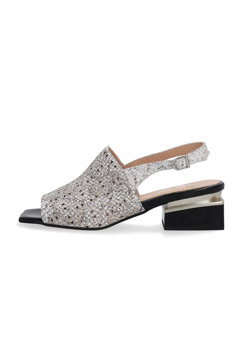 Sølv slingback sko med trekantet tå, perlemønster, åben hæl og en to-tone blokhælg med sorte og metalliske accenter.