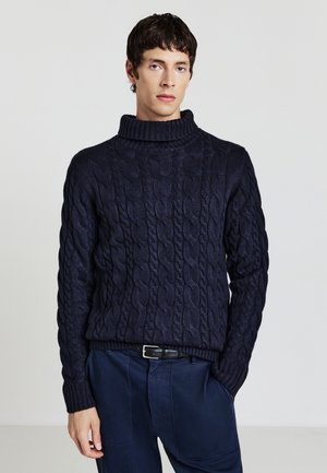 Maglione a collo alto in misto lana blu navy con motivo a treccia, polsini e orlo ribattuti. Abbinato a pantaloni scuri, in una vestibilità comoda.