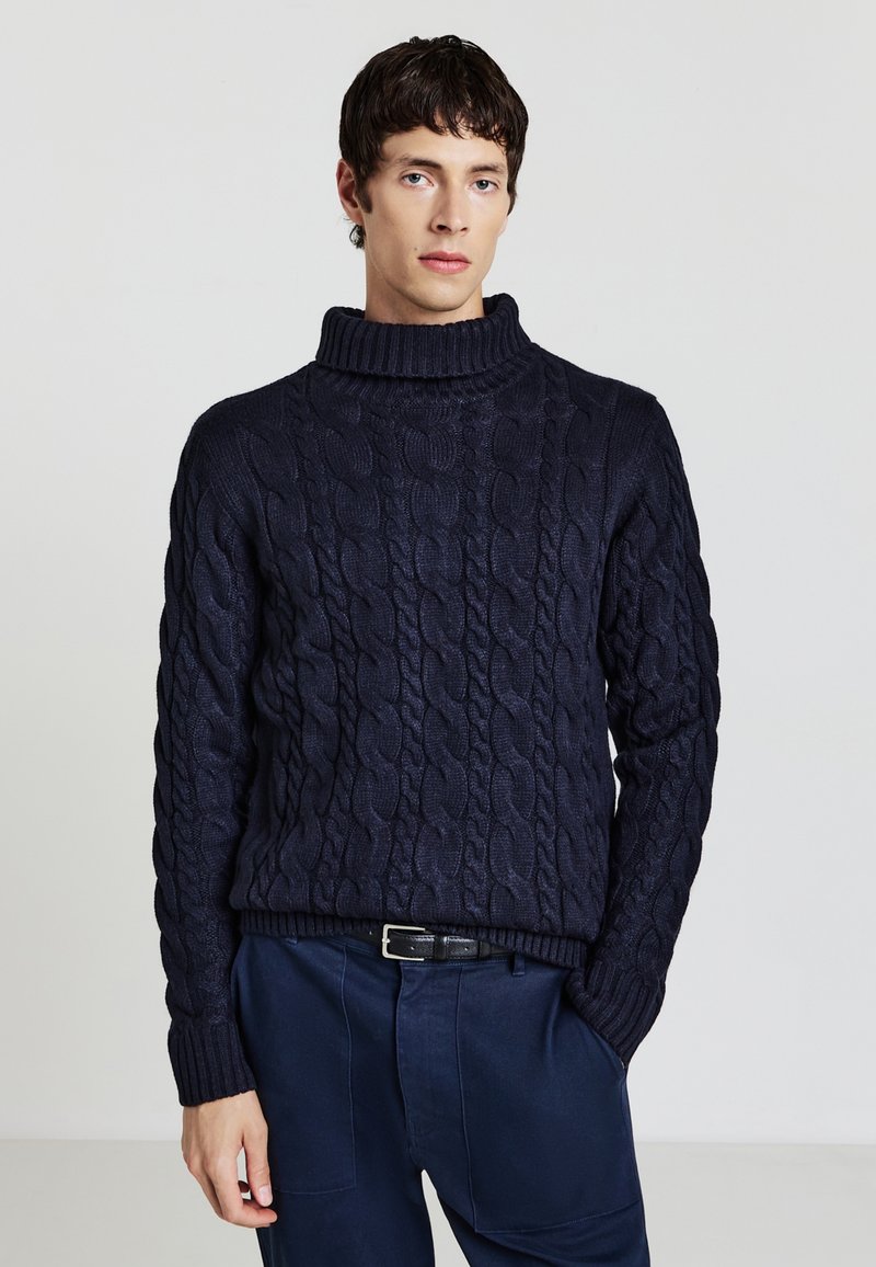 Maglione a collo alto in misto lana blu navy con motivo a treccia, polsini e orlo ribattuti. Abbinato a pantaloni scuri, in una vestibilità comoda.