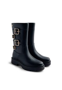 Botas de cuero negro hasta la rodilla con tres detalles en hebilla dorada, punta redondeada y una suela de goma texturizada para mayor agarre.