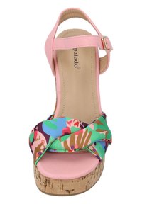 Sandal de cuña colorido que presenta una tira sintética rosa y una parte superior de tela con patrón floral. El tacón de corcho añade textura y altura.