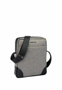 Graue Umhängetasche aus Stoff mit schwarzen Ecken, verstellbarem schwarzem Riemen, Vordertasche und "Cerruti 1881"-Logo auf weißem Hintergrund.