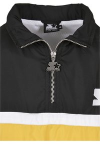 Veste noire, blanche et jaune avec une demi-fermeture éclair équipée d'un curseur métallique avec le logo Starter et une doublure intérieure en mesh.