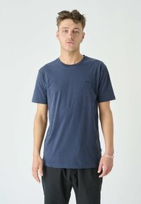 Navyblaue Baumwoll-T-Shirt mit kurzen Ärmeln und Rundhalsausschnitt, ausgestattet mit einem kleinen Logo auf der Brust und einem lockeren Schnitt.