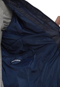 Giacca impacchettabile blu navy con interni lisci, dotata di tasca con zip e tessuto leggero e resistente all'acqua.