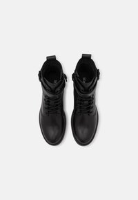 Bottes noires montantes en cuir lisse avec un design à lacets, une fermeture éclair latérale et des accents de boucle réglable à la cheville.