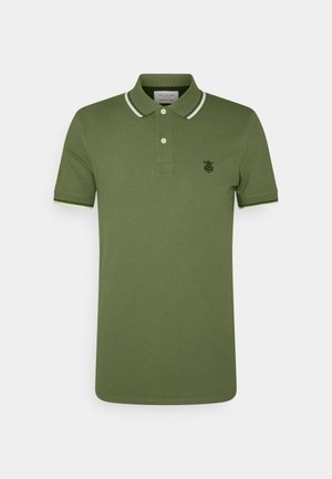 Polo vert olive en coton, avec une patte de boutonnière à deux boutons, un col blanc, et un petit logo brodé sur la poitrine.