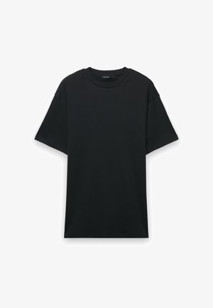 T-shirt in cotone nero con maniche corte, scollo rotondo e vestibilità comoda. Texture liscia senza motivi o grafiche visibili.