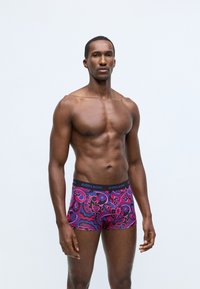 Zásielka boxeriek v jasnej purpurovej látke s výrazným vzorom paisley. Elastický pás je čierny s brandingom "BJÖRN BORG".