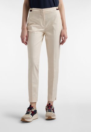 Beige op maat gemaakte broek met een gladde textuur, voorzien van een slanke pasvorm en zijstrepen. Gecombineerd met multicolor sneakers voor contrast.