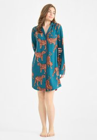 Teal nachthemd met lange mouwen en tijgerprint. Beschikt over een knoopsluiting aan de voorkant, kraag en een patchzak. Zachte stof met levendige oranje details.