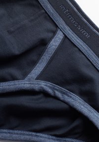 Granatowe majtki z gładkiego materiału z miękkim paskiem. Kontrastowe przeszycia w jaśniejszym odcieniu niebieskiego wzdłuż brzegów.