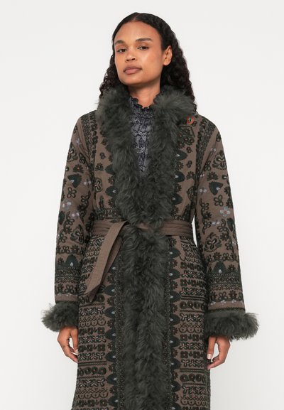 Μακρύ, καφέ παλτό με σχέδια και ύφασμα από συνθετική γούνα στον λαιμό και στα μανίκια. Διακοσμημένο με λουλουδάτα σχέδια και ζώνη στη μέση, προσφέροντας υφή.