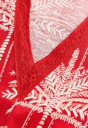 Vêtement rouge ornée de motifs de fougère en blanc, avec un décolleté en V bordé de dentelle. Le tissu est lisse et léger, mettant en valeur des détails élaborés.