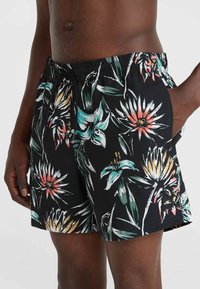 Los pantalones cortos de baño presentan un fondo negro con patrones florales multicolores, fabricados con un material liviano, con una cintura elástica y bolsillos laterales.