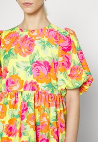 Blumenkleid mit gelbem Hintergrund und rosa sowie orangefarbenen Rosen, kurzen puffärmel und gerafftem Taillenbereich. Strukturierten Stoff.