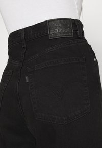 Levi's® HIGH LOOSE - Calças de ganga à boca de sino - black denim