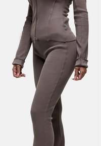 Ensemble en deux pièces côtelé de couleur marron muted ; design ajusté avec une veste zippée et un pantalon taille haute ; tissu texturé avec des manches longues et des poignets.