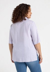 Camicetta a strisce viola chiaro con maniche corte e orlo dritto, realizzata in un tessuto leggero, con dettagli a spacco laterale.
