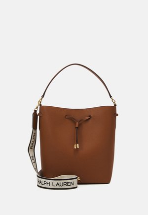 Brązowa skórzana torba typu bucket z zapięciem na sznurek, pojedynczą rączką i odpinanym białym paskiem z czarnym napisem "RALPH LAUREN".