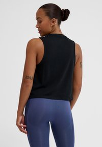 Schwarzes ärmelloses Crop-Top mit lockerer Passform, aus weichem Stoff gefertigt, mit rundem Halsausschnitt und einfachem Design.