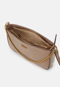 Beige taske med krokodillepræg og en guld kædeline, der har flere lynlåskompartments og et brandet interiør. Glat tekstur, rektangulær form.