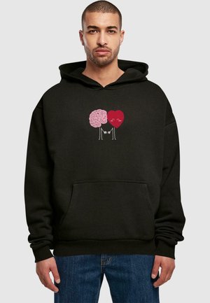 Sort hoodie med et pink hjerne- og rød hjertegrafik på brystet, med smilende ansigt og arme der holder hænder, samt en frontlomme.