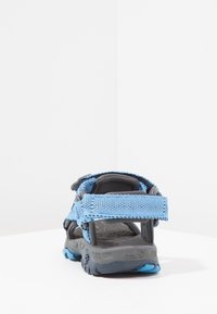 Modrá síťovaná sandálka s šedou gumovou podrážkou. Má nastavitelné pásky a texturovanou stélku. Lehký design vhodný pro venkovní použití.