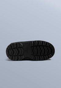 Černá gumová podrážka s hlubokým vzorem běhounu pro lepší trakci, se strukturovaným povrchem a zaoblenými hranami. Viditelná velikostní značka: 37.