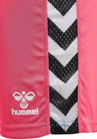 Rosa sportströja med en slät textur som har ett svartvitt chevronmönster på sidan. Logotypen är tryckt i vitt.