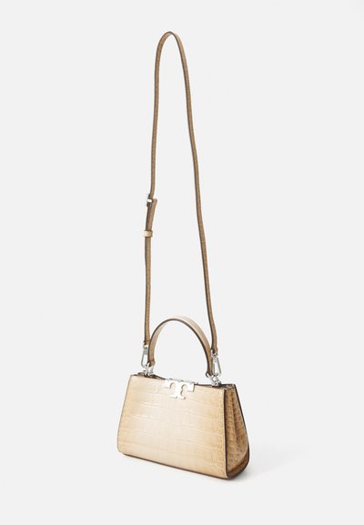 Beige crocodile-embossed handbag with a structured design, short handle, and adjustable strap. Silver hardware accentuates the closure.