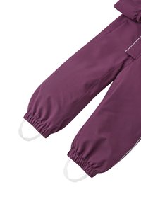 Lila barnoverall med elastiska ärmslut, stövlar och reflektorer på sidorna. Tillverkade av ett glatt, vattenavvisande tyg.