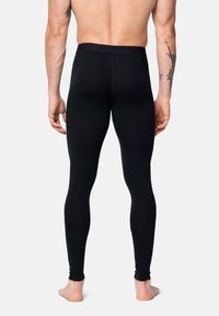 Leggings neri realizzati in un materiale elasticizzato e aderente, con una texture liscia e una vita alta, visti da dietro.