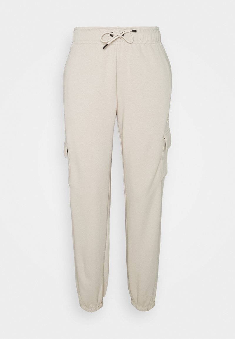 Beige sweatpants in soft fabric with an elastic waistband and adjustable drawstring. Features side cargo pockets and tapered ankles.